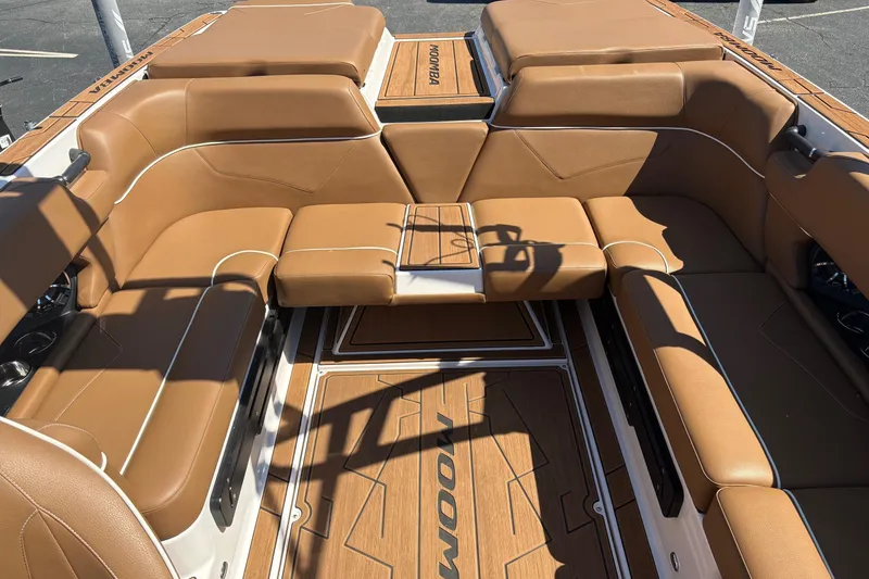 Slide: The Image of 2023 Moomba Kaiyen boat interior with tan leather seating and wood accents. - 10