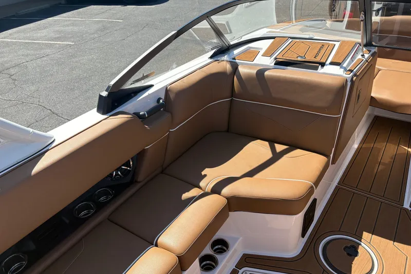 Slide: The Image of 2023 Moomba Kaiyen boat interior with tan leather seating and wood accents. - 11