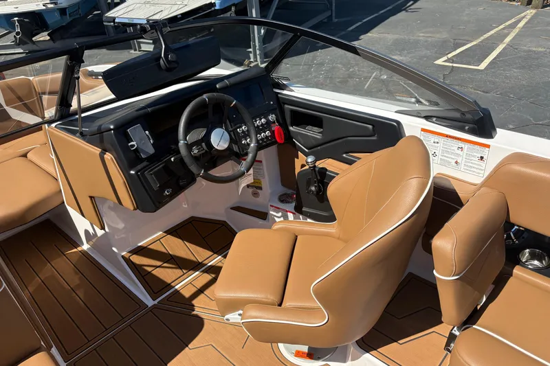 Slide: The Image of 2023 Moomba Kaiyen boat interior with tan leather seats and modern dashboard controls. - 12