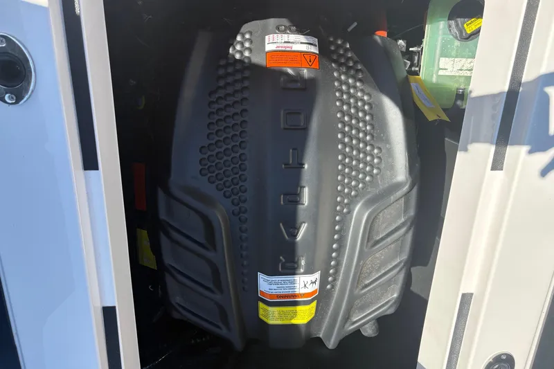 Slide: The Image of 2023 Moomba Kaiyen engine compartment with protective cover and warning labels. - 15