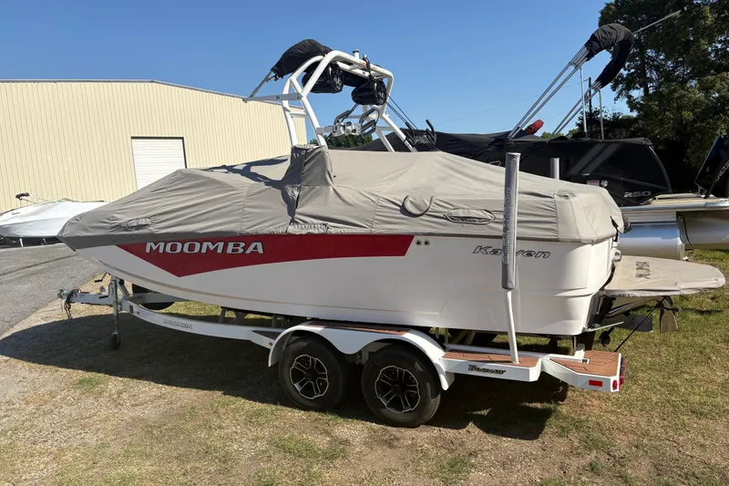 Slide: The Image of 2023 Moomba Kaiyen boat covered on trailer, parked outdoors near storage facility. - 4