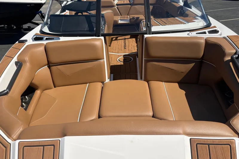 Slide: The Image of 2023 Moomba Kaiyen boat interior with tan leather seating and wood accents. - 6