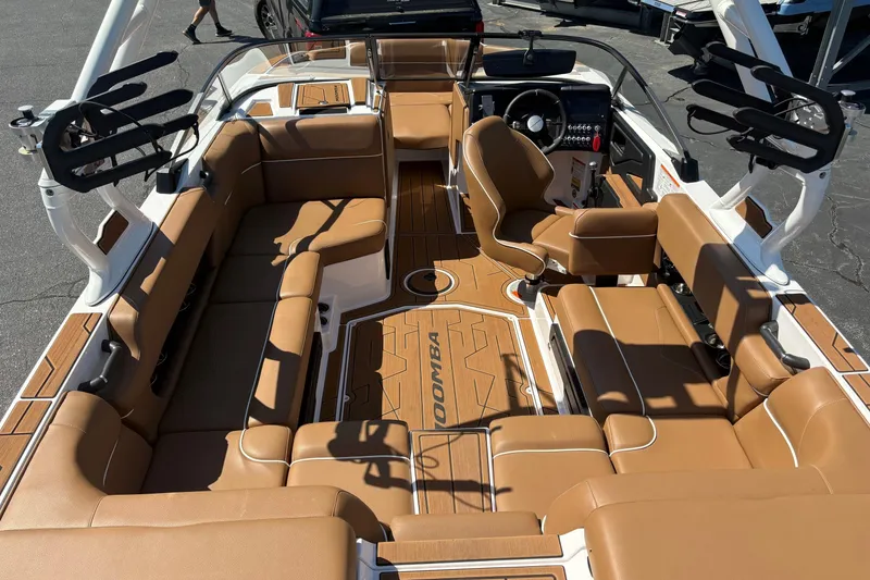 Slide: The Image of 2023 Moomba Kaiyen boat interior with tan seating and sleek dashboard design. - 7