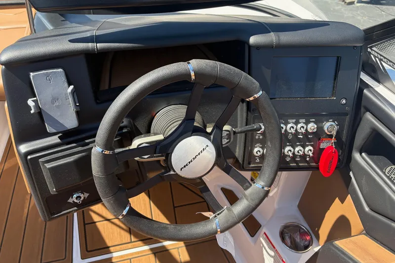 Slide: The Image of 2023 Moomba Kaiyen boat dashboard with steering wheel and control panel. - 8