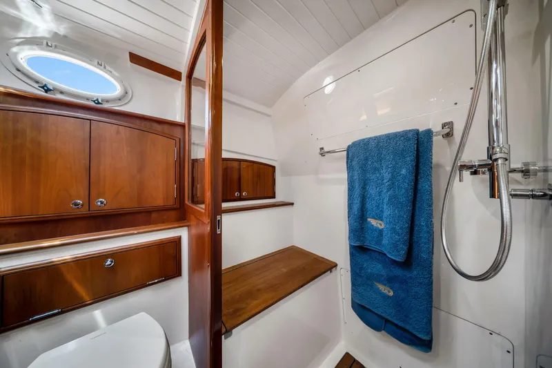 Slide: The Image of Luxurious bathroom interior of 2020 Hinckley Picnic Boat 40 with wooden cabinetry and blue towels. - 14