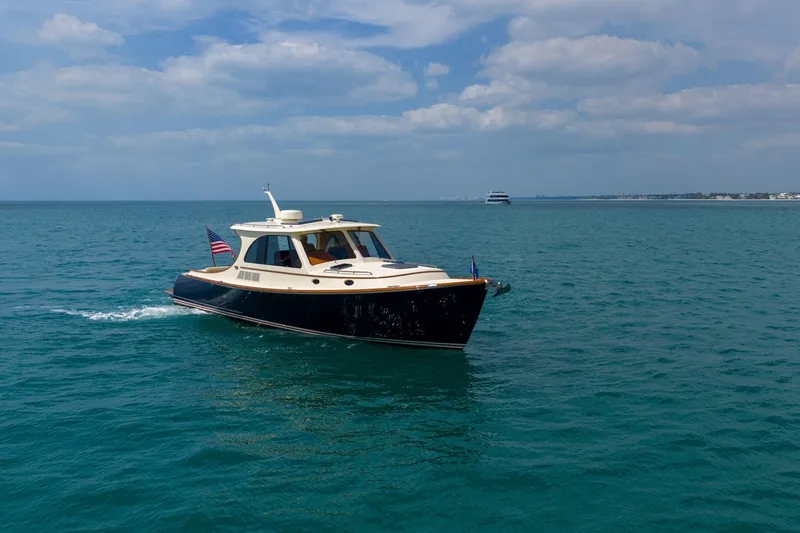 Slide: The Image of 2020 Hinckley Picnic Boat 40 cruising on open water under a partly cloudy sky. - 15