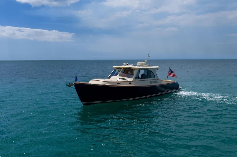 Slide: The Image of 2020 Hinckley Picnic Boat 40 cruising on open water under a cloudy sky. - 16