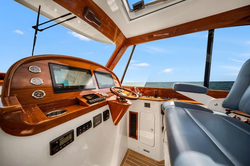Slide: The Image of Helm of 2020 Hinckley Picnic Boat 40 with modern navigation displays and luxurious seating. - 7