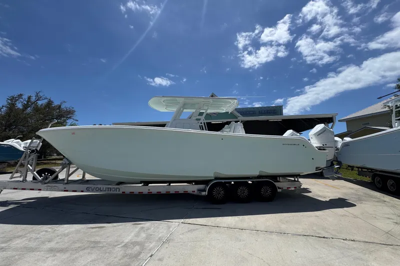 The Image of 2024 Invincible 33 Catamaran on trailer under clear blue sky. - 1