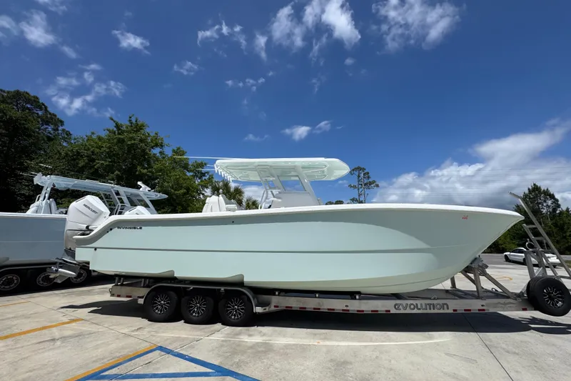 Slide: The Image of 2024 Invincible 33 Catamaran on trailer under blue sky. - 10