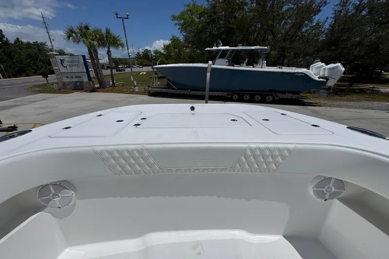 Slide: The Image of 2024 Invincible 33 Catamaran at a marina with palm trees and a parked boat. - 21