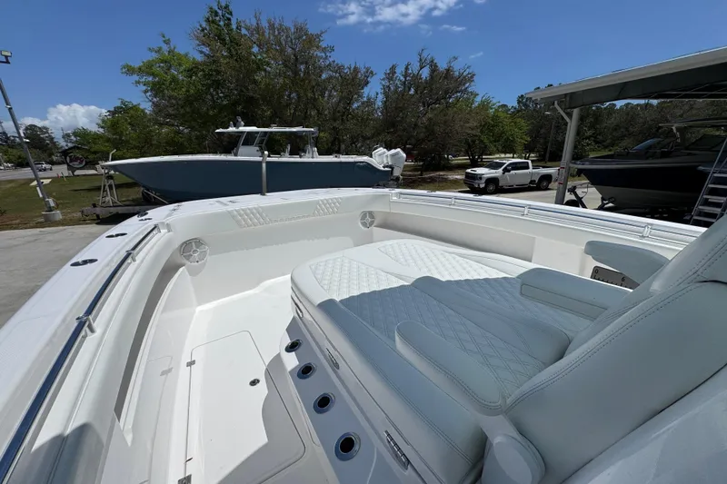 Slide: The Image of 2024 Invincible 33 Catamaran with spacious seating, docked outdoors under clear skies. - 22