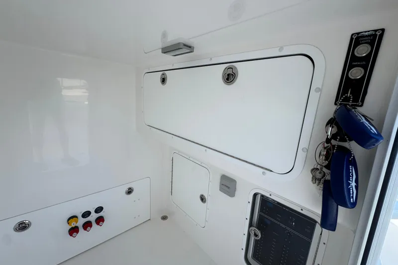 Slide: The Image of Interior view of 2024 Invincible 33 Catamaran control panel and storage compartments. - 25