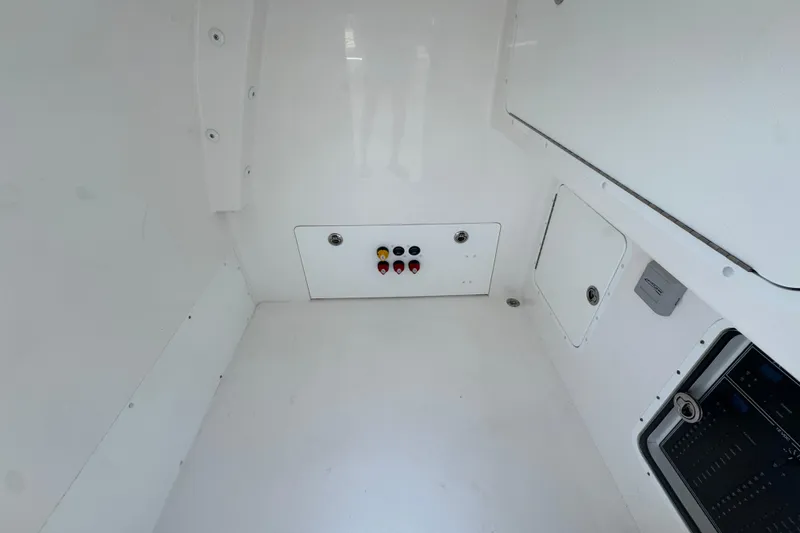 Slide: The Image of 2024 Invincible 33 Catamaran interior with control panel and storage compartments. - 26
