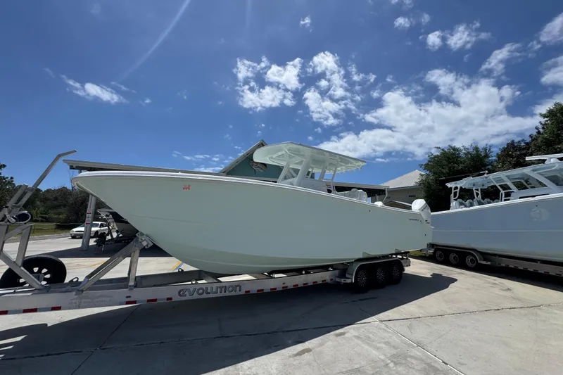 Slide: The Image of 2024 Invincible 33 Catamaran on trailer under clear blue sky. - 3