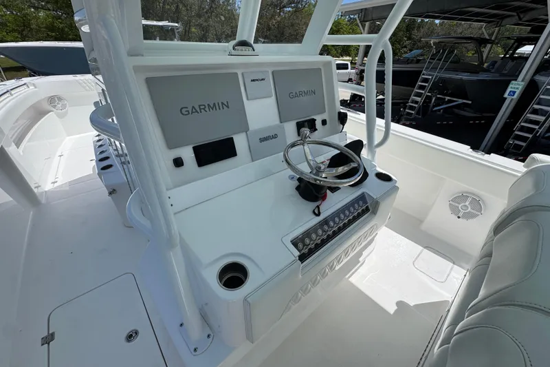 Slide: The Image of 2024 Invincible 33 Catamaran helm with Garmin displays and steering wheel. - 31