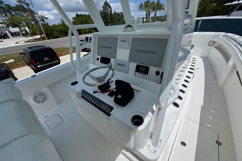 Slide: The Image of 2024 Invincible 33 Catamaran helm with Garmin displays and steering wheel. - 33