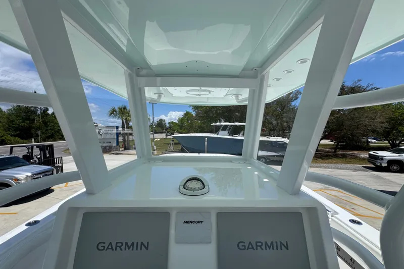 Slide: The Image of 2024 Invincible 33 Catamaran helm with Garmin displays and Mercury controls. - 34