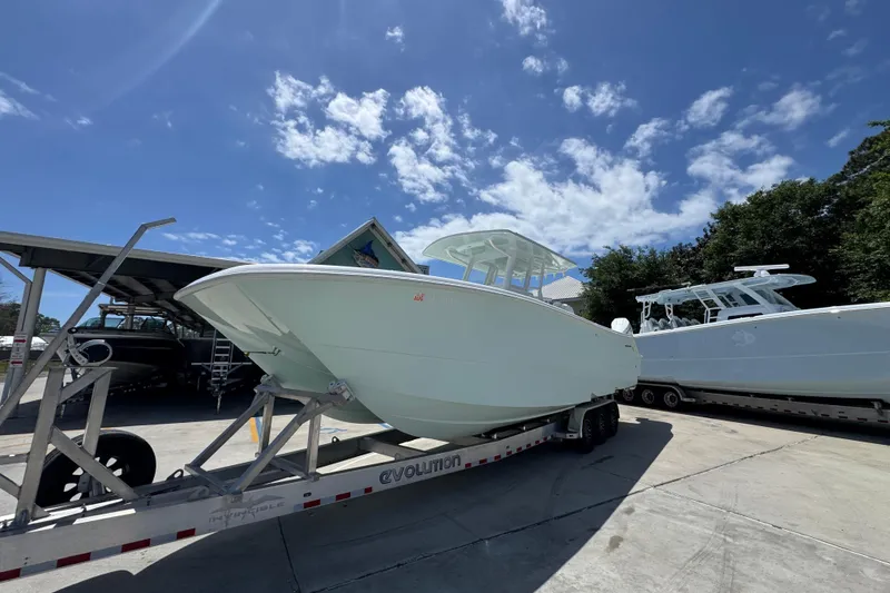 Slide: The Image of 2024 Invincible 33 Catamaran on trailer under clear blue sky. - 4