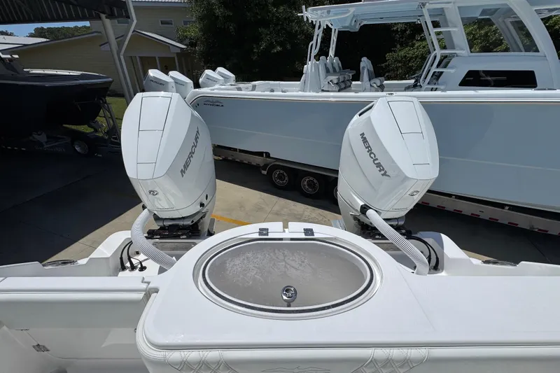 Slide: The Image of 2024 Invincible 33 Catamaran with dual Mercury outboard engines, docked outdoors. - 41