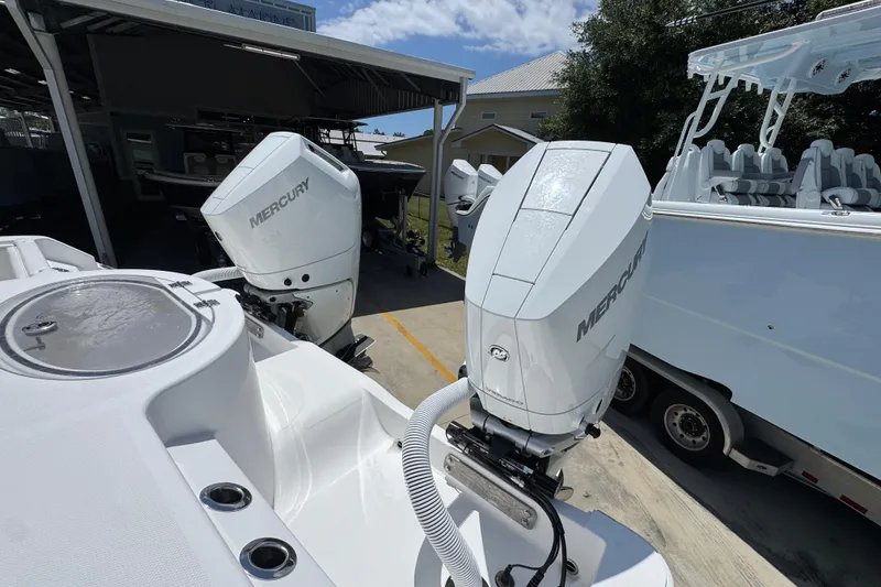 Slide: The Image of 2024 Invincible 33 Catamaran with dual Mercury outboard engines in a marina setting. - 42