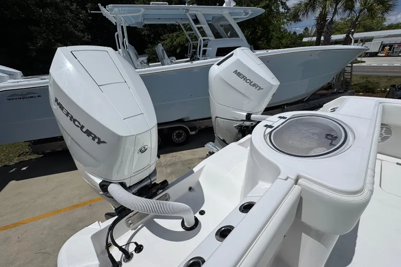 Slide: The Image of 2024 Invincible 33 Catamaran with dual Mercury outboard engines, docked outdoors. - 43