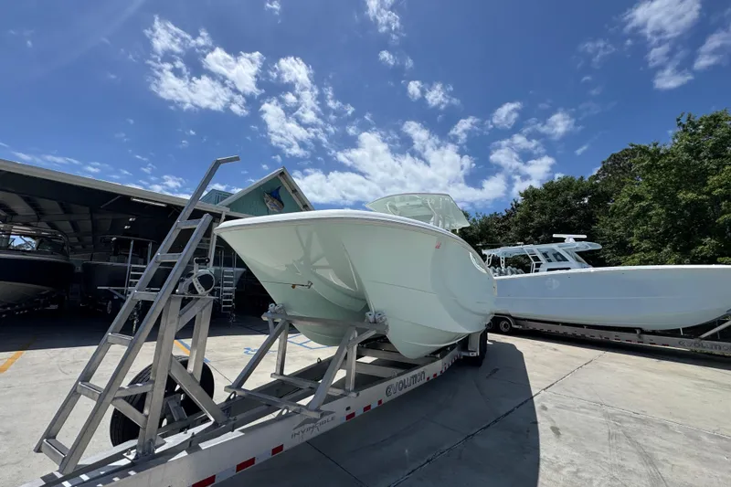 Slide: The Image of 2024 Invincible 33 Catamaran on trailer under clear blue sky. - 5