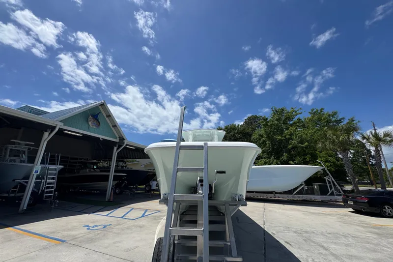 Slide: The Image of 2024 Invincible 33 Catamaran on trailer under clear blue sky. - 6