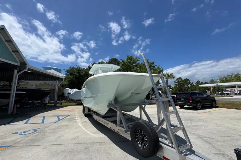 Slide: The Image of 2024 Invincible 33 Catamaran on trailer under clear blue sky. - 7