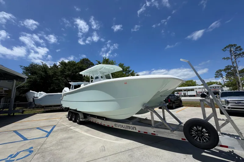 Slide: The Image of 2024 Invincible 33 Catamaran on trailer under clear blue sky. - 8