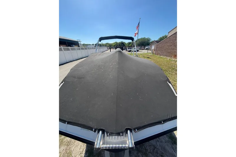 Slide: The Image of 2023 Starcraft SVX 191 OB boat with cover, parked outdoors under clear blue sky. - 15