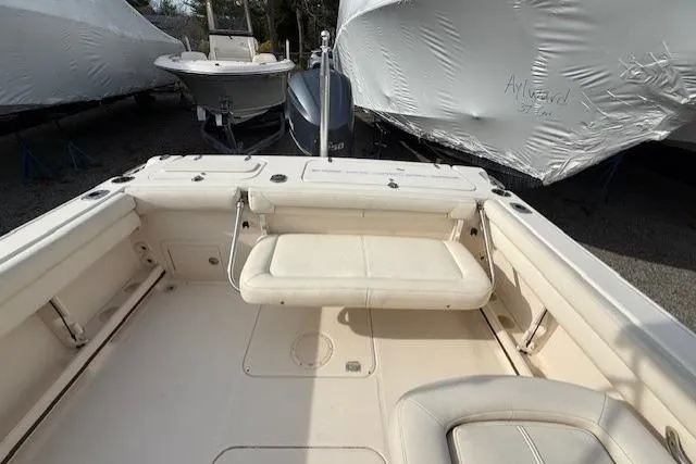 Slide: The Image of 2015 Grady-White Freedom 225 boat interior with seating and covered boats in background. - 11