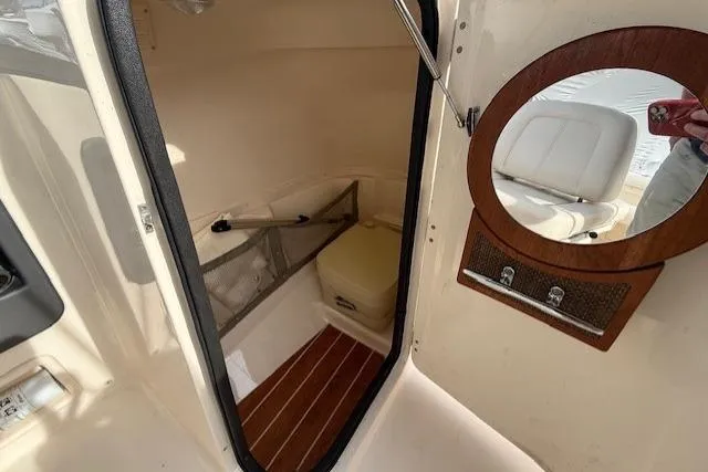 Slide: The Image of 2015 Grady-White Freedom 225 boat interior with wooden flooring and round mirror. - 14