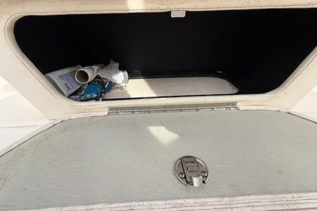 Slide: The Image of Storage compartment of 2015 Grady-White Freedom 225 boat, partially open with items inside. - 36