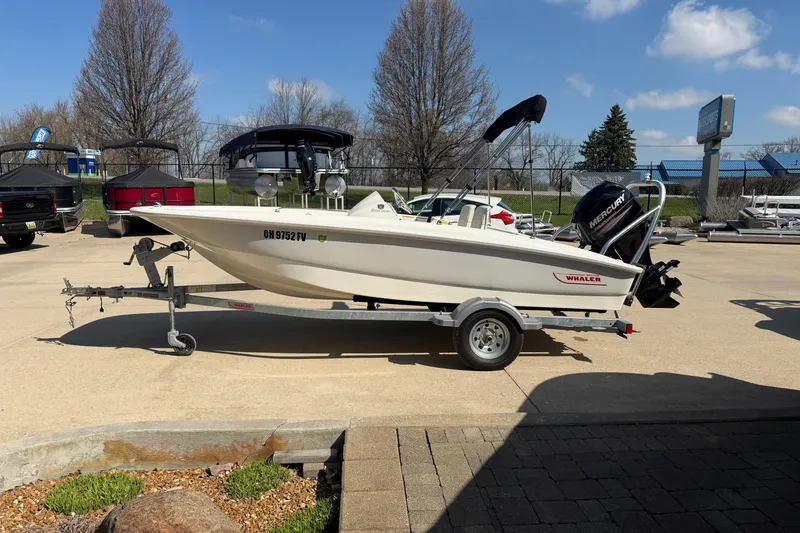 Slide: The Image of 2018 Boston Whaler 150 Super Sport boat on trailer in outdoor setting. - 3