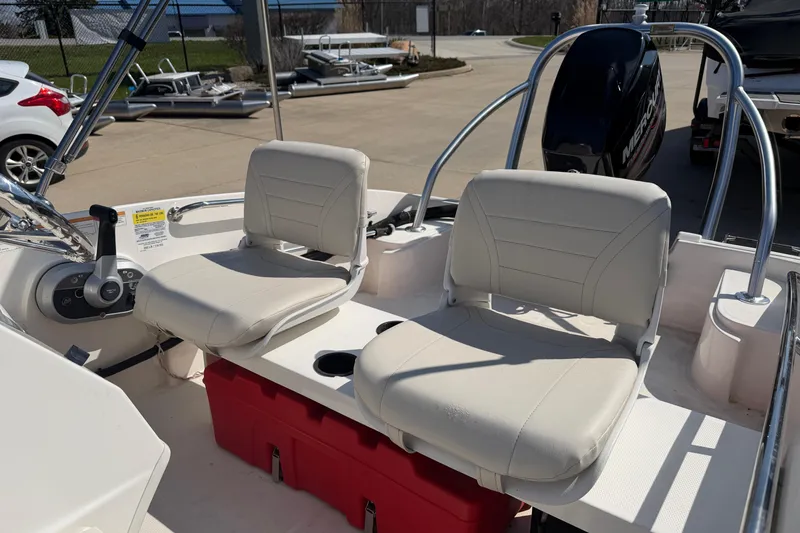 Slide: The Image of 2018 Boston Whaler 150 Super Sport boat interior with dual seats and steering console. - 5