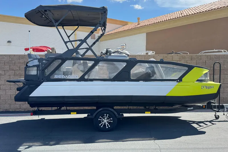 The Image of 2022 Sea-Doo Switch Sport 21 pontoon boat with canopy, parked on trailer. - 0