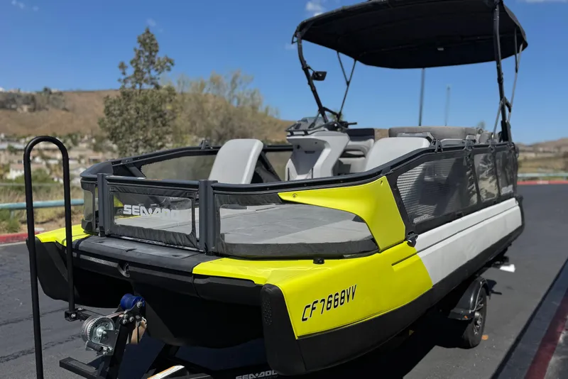Slide: The Image of 2022 Sea-Doo Switch Sport 21 pontoon boat with vibrant yellow accents on a trailer. - 3