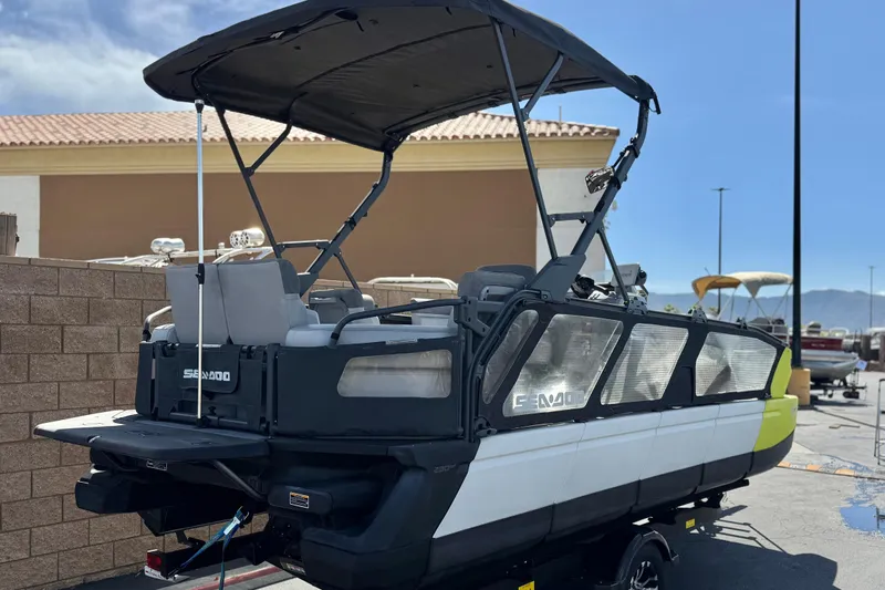 Slide: The Image of 2022 Sea-Doo Switch Sport 21 pontoon boat with canopy, parked outdoors. - 7