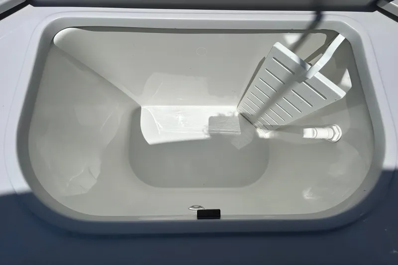 Slide: The Image of Livewell compartment in 2022 Godfrey Sweetwater 2286FS boat, featuring a drain and divider. - 103