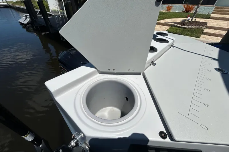 Slide: The Image of 2022 Godfrey Sweetwater 2286FS boat with open storage compartment and measuring scale on deck. - 105