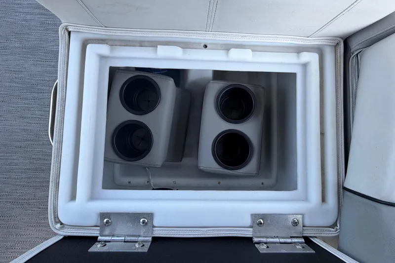 Slide: The Image of An open storage compartment with cup holders inside a boat. - 41