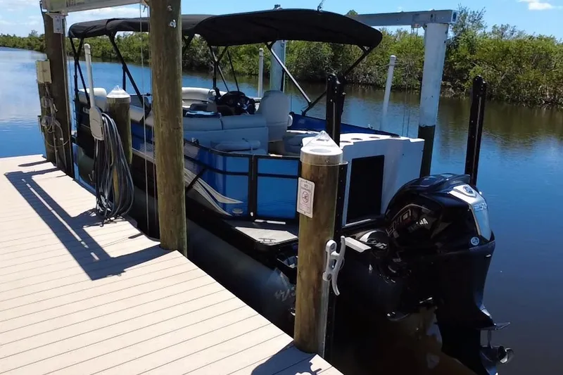 Slide: The Image of 2022 Godfrey Sweetwater 2286FS pontoon boat docked by a serene waterway. - 16