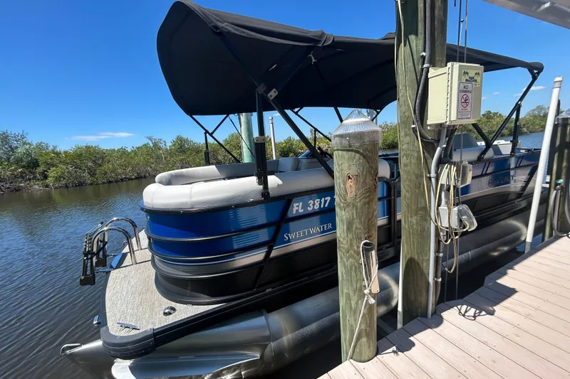 Slide: The Image of 2022 Godfrey Sweetwater 2286FS pontoon boat docked on a sunny day. - 18