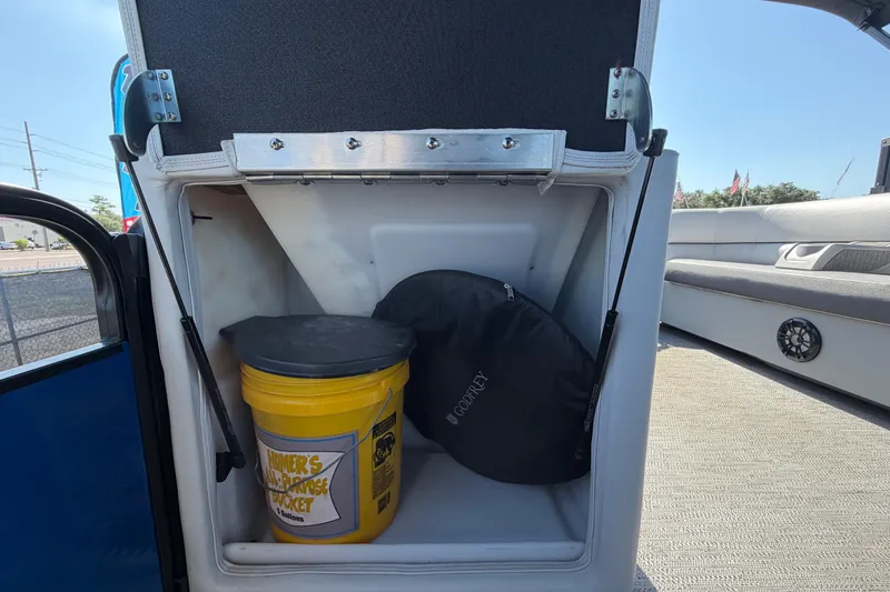 Slide: The Image of Storage compartment in a 2022 Godfrey Sweetwater 2286FS boat with bucket and cover. - 74