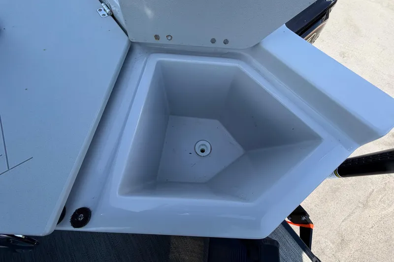 Slide: The Image of Open storage compartment on 2022 Godfrey Sweetwater 2286FS boat, featuring a triangular design. - 51
