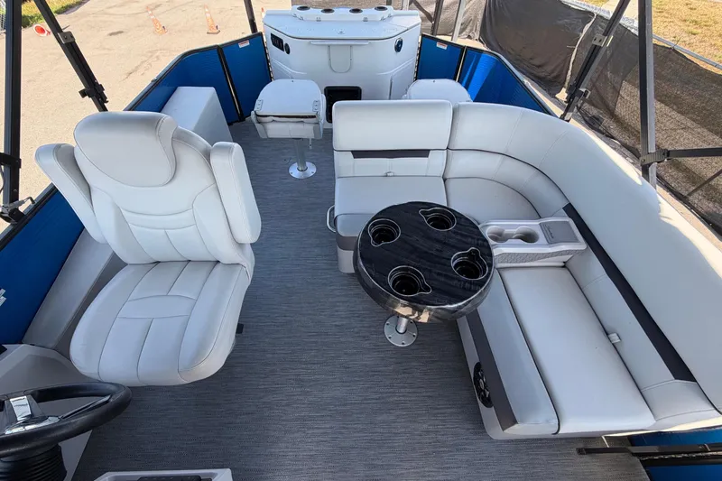 Slide: The Image of Interior of a Godfrey Sweetwater 2286FS pontoon boat with white seating and a round table. - 24