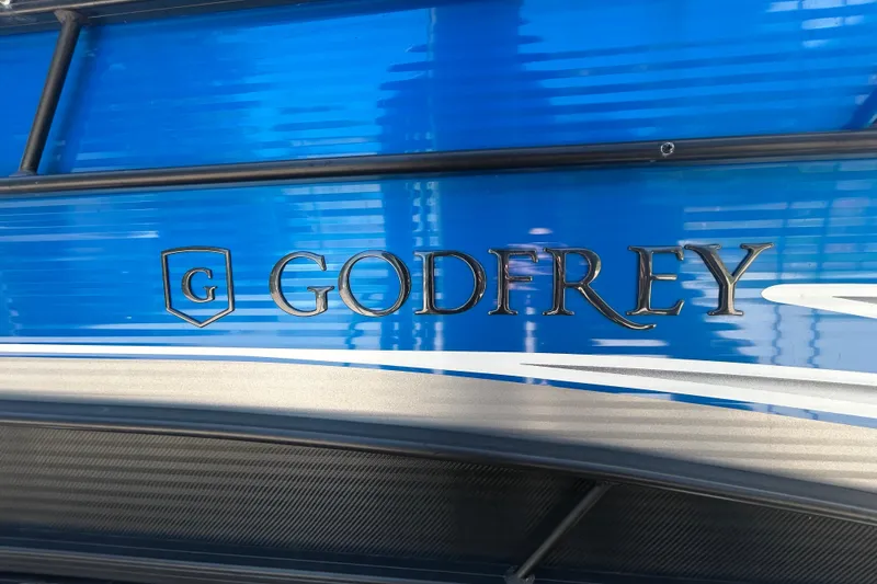 Slide: The Image of 2022 Godfrey Sweetwater 2286FS boat with blue exterior and logo detail. - 22
