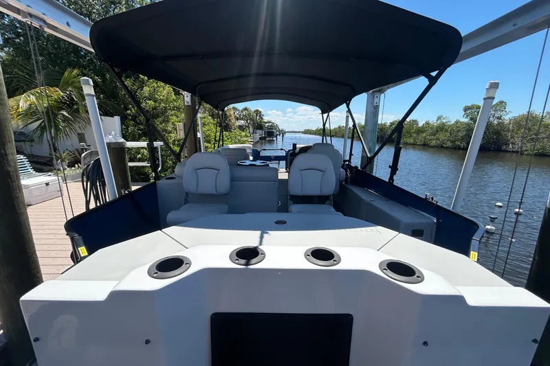 Slide: The Image of 2022 Godfrey Sweetwater 2286FS pontoon boat docked by a scenic river. - 24