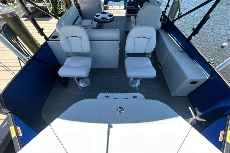 Slide: The Image of Interior of 2022 Godfrey Sweetwater 2286FS pontoon boat with white seating and blue accents. - 25